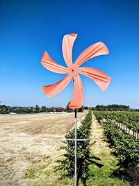 Traditional windmill on field against clear blue sky