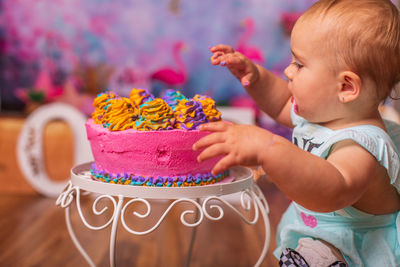 Close-up of cute baby girl playing in frosting