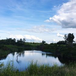 Scenic view of calm lake against cloudy sky