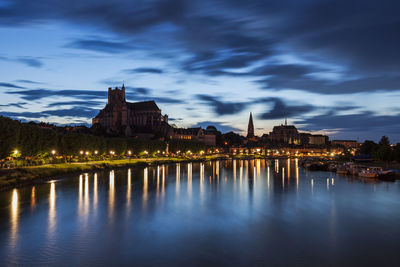 Buildings by river against sky