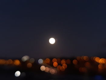 Defocused lights against sky at night