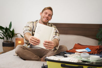 Portrait of smiling friends using digital tablet while sitting on sofa at home