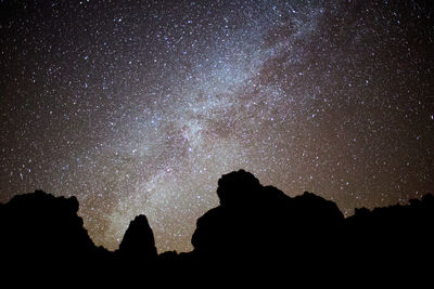 Low angle view of silhouette mountain against sky at night