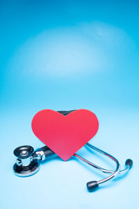 Close-up of heart shape on table against blue background