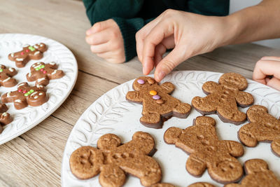 Cropped image of mother preparing cookie at home