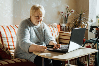 Man using laptop while sitting on table