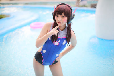 Young woman standing against swimming pool