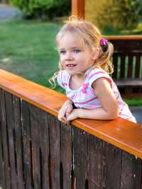 Portrait of smiling girl sitting on wood