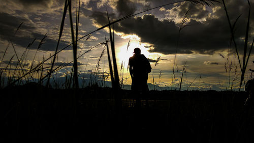 Silhouette man standing against sky during sunset