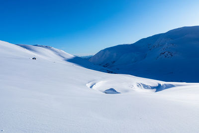 Scenic view of snowcapped mountains against clear blue sky