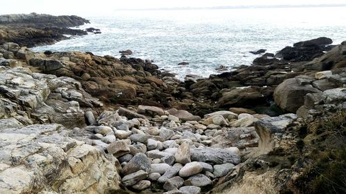 Rocks by sea against sky