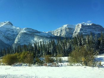 Scenic view of snowcapped mountains against blue sky