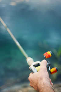 Close-up of hand holding fishing rod