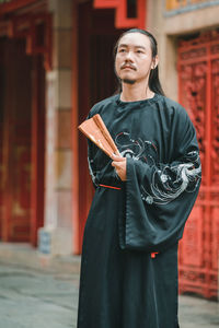 Portrait of smiling young woman standing in city