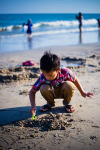 Boy playing on sand at beach