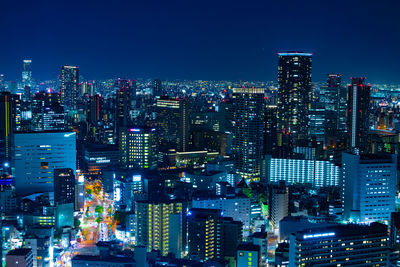 Illuminated cityscape against clear sky at night