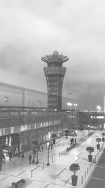 People in illuminated city against sky