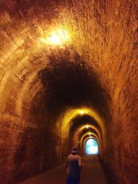 Man standing in illuminated tunnel