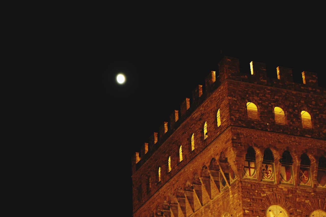 illuminated, night, lighting equipment, built structure, architecture, low angle view, copy space, building exterior, glowing, light - natural phenomenon, dark, street light, clear sky, no people, moon, sky, outdoors, electric light, city, in a row