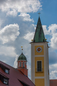 Low angle view of clock tower amidst buildings against sky