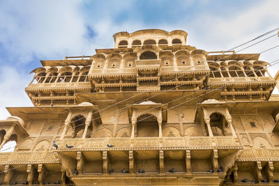 Low angle view of old building against cloudy sky