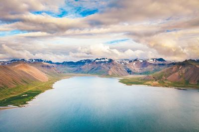 Scenic view of lake by mountains against sky