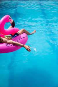 Man relaxing in inflatable ring on swimming pool