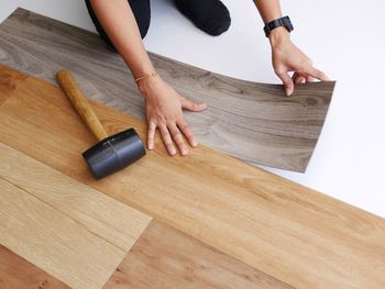 Cropped hands of woman adjusting planks on floor