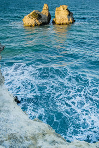 Scenic view of rock formations on sea against clear sky