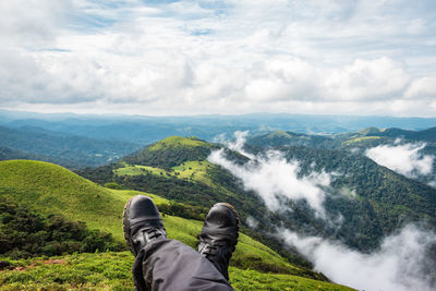 Low section of man on mountain against sky