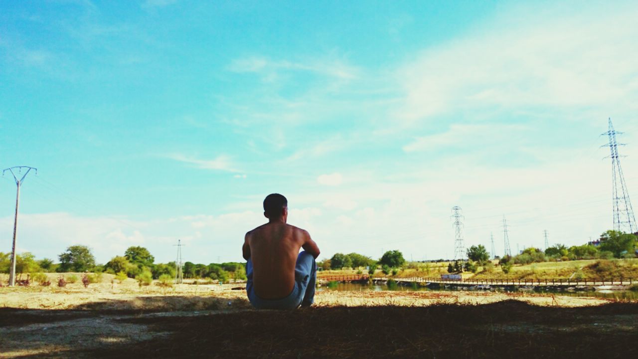 rear view, sky, lifestyles, full length, men, standing, leisure activity, cloud - sky, casual clothing, cloud, landscape, field, nature, tranquility, person, tranquil scene, tree, beauty in nature