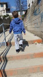 Rear view of boy walking on staircase