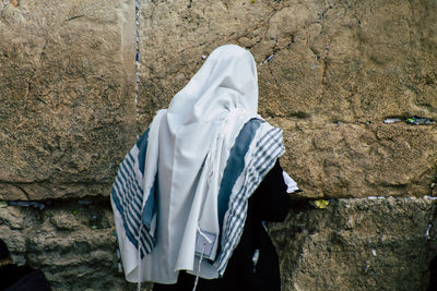 Midsection of man hanging against wall