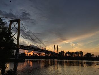 Bridge over river against cloudy sky