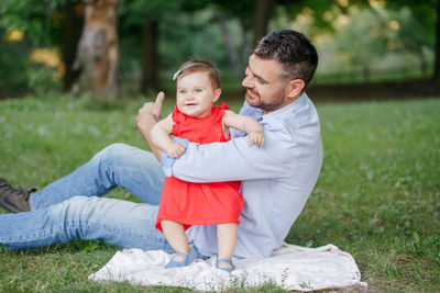 Full length of father and daughter on grass