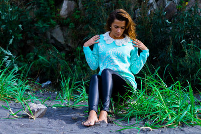 Portrait of young woman standing against plants