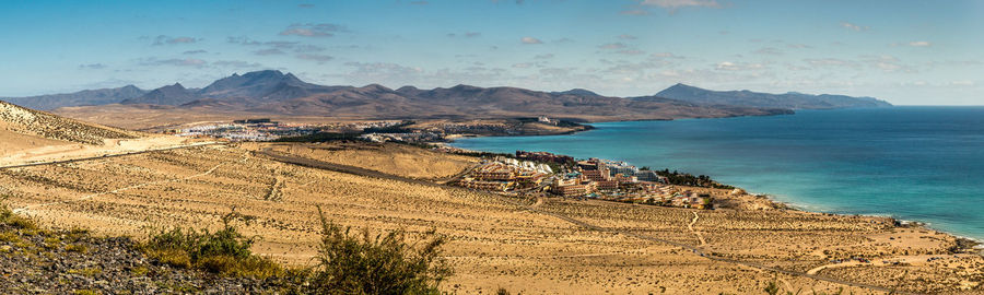 Scenic view of sea and mountains against sky