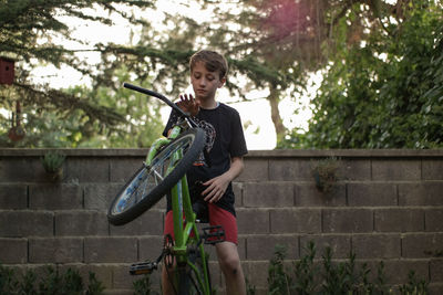 
portrait of boy riding bmx in the garden