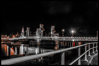 Illuminated bridge against sky at night