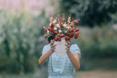  girl holding flowering plant