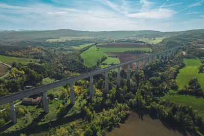 Panoramic view from a drone on passenger train crossing the railway flyover.