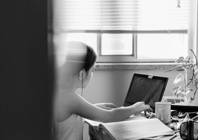 Side view of girl studying at home