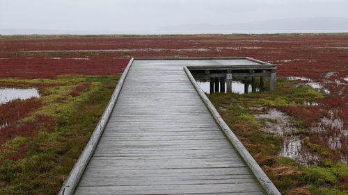 View of wooden structure on landscape against sky