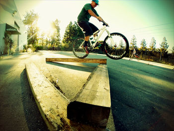 Rear view of woman jumping on road