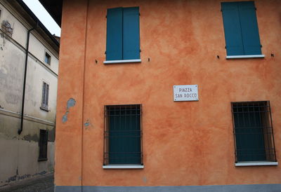 Sign board by windows on building exterior