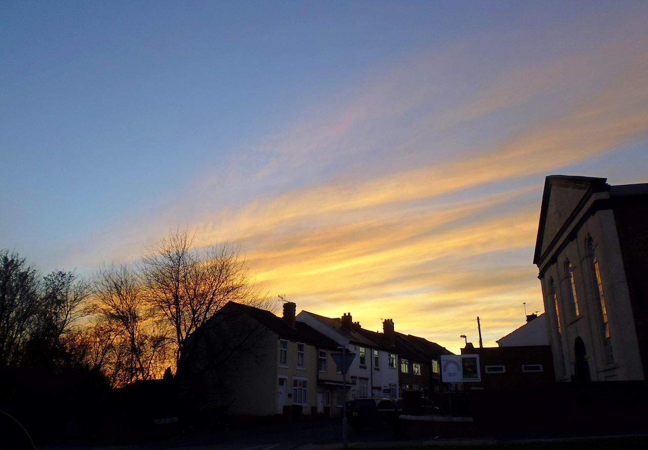 HOUSES IN CITY AGAINST SKY AT SUNSET