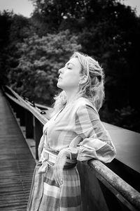 Blonde woman leaning on a bridge ii