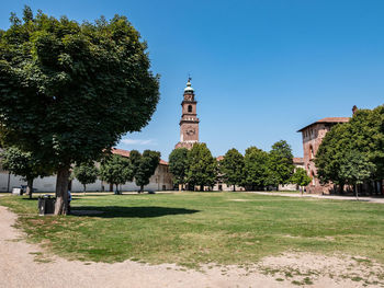 View of trees and building against blue sky