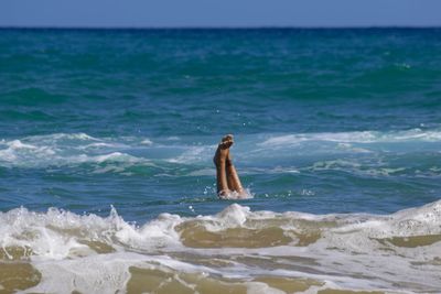 Man surfing in sea against sky