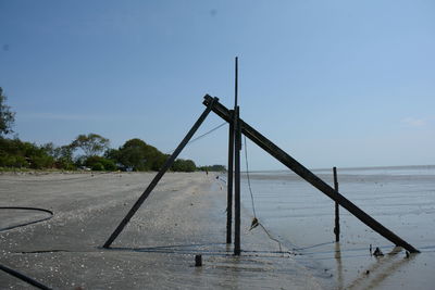 Metallic structure on field against clear blue sky